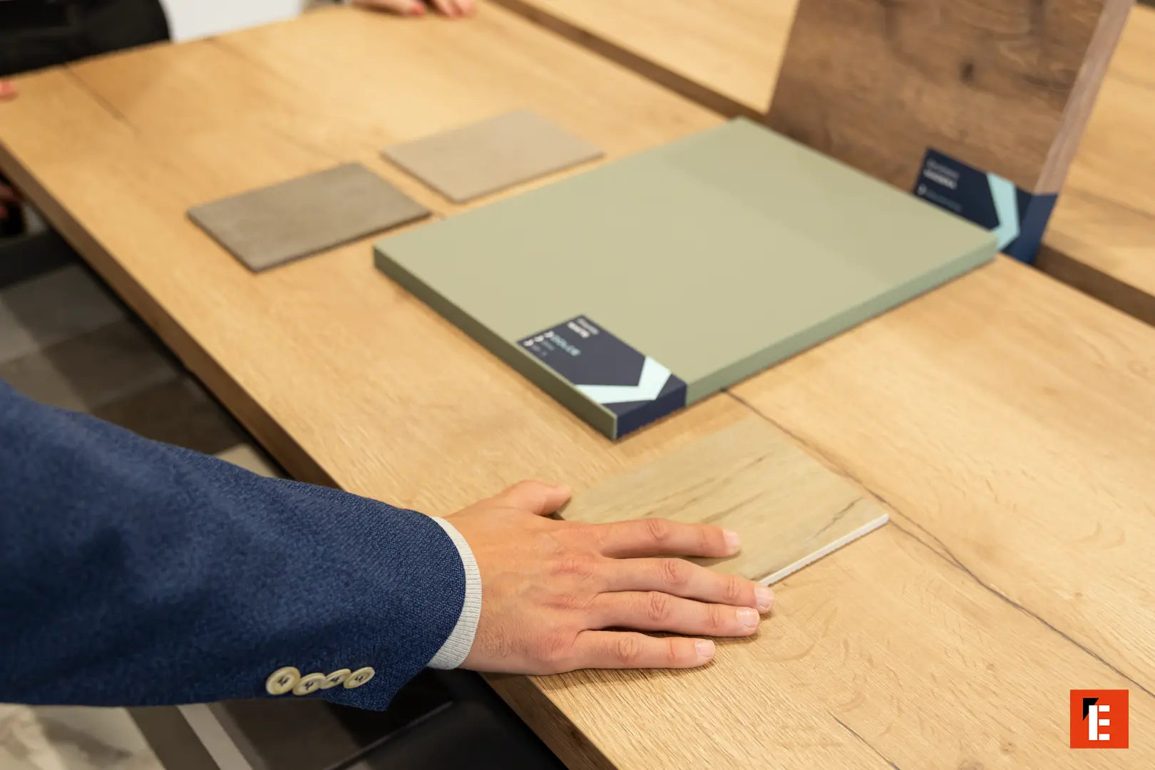 Muestras de acabados, maderas y encimeras sobre la mesa del showroom de ixina